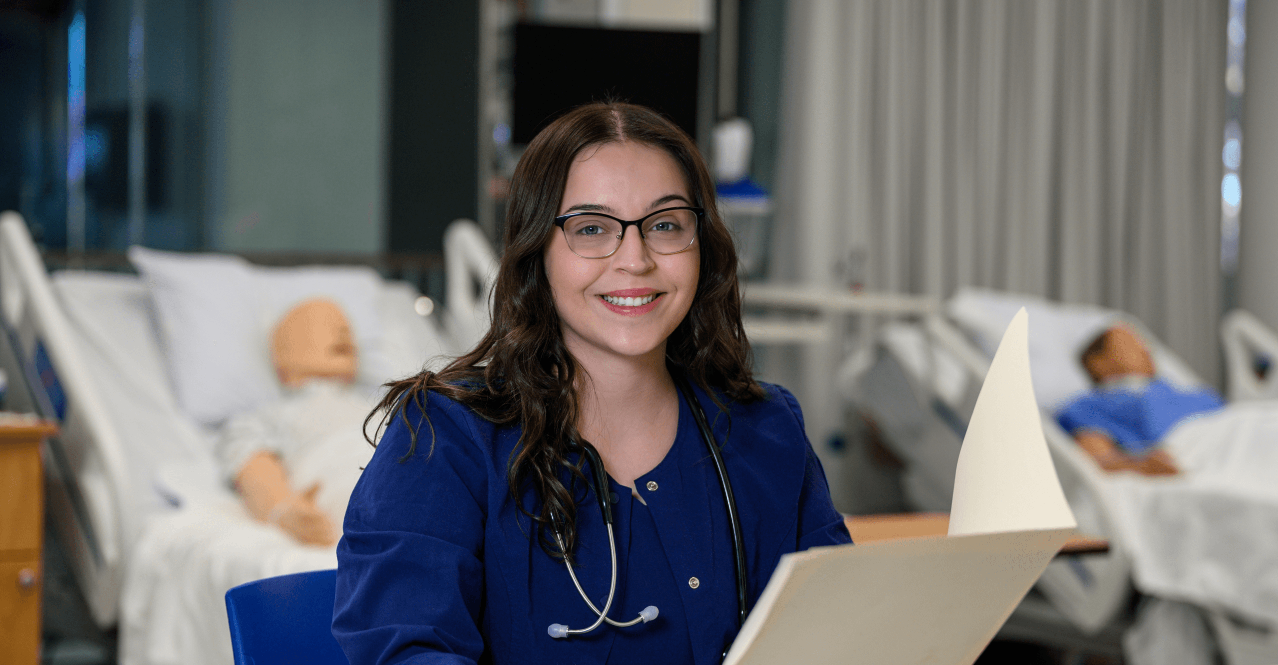 Young woman wearing nurse scrubs smiling at the camera